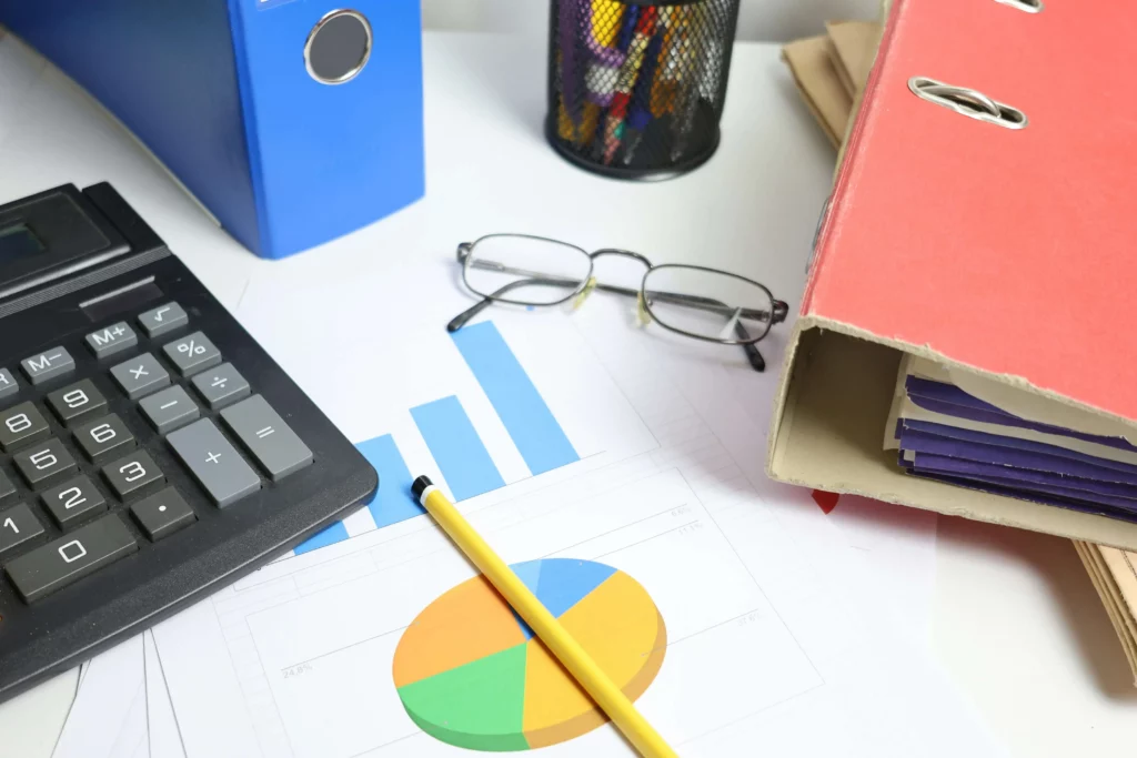 Mesa de escritório contábil com documentos fiscais, calculadora e 
smartphone aberto — rotina de atendimento manual que pode ser 
automatizada via WhatsApp contabilidade
